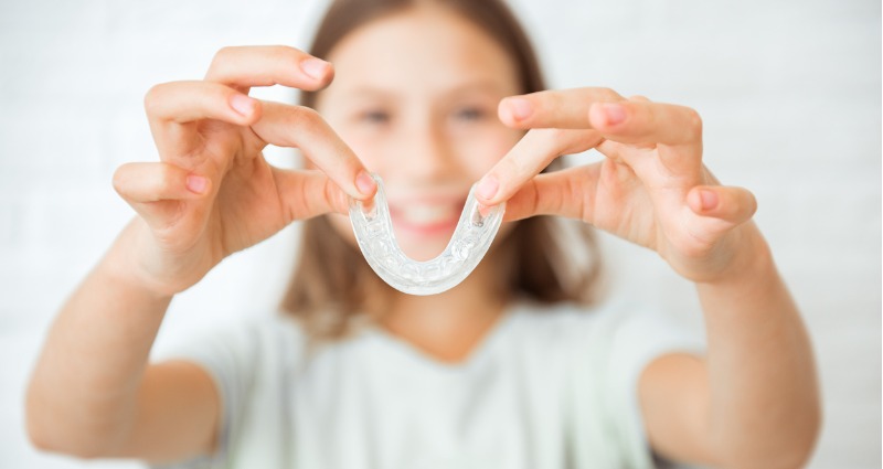 Hình ảnh người phụ nữ cầm khay niềng răng trong suốt